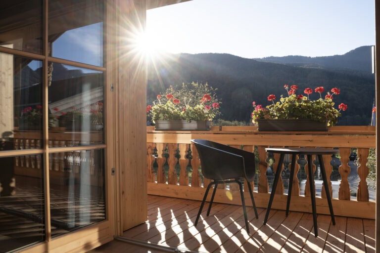 Sonniger Balkon mit Design-Sitzgruppe – Blick auf die Berge