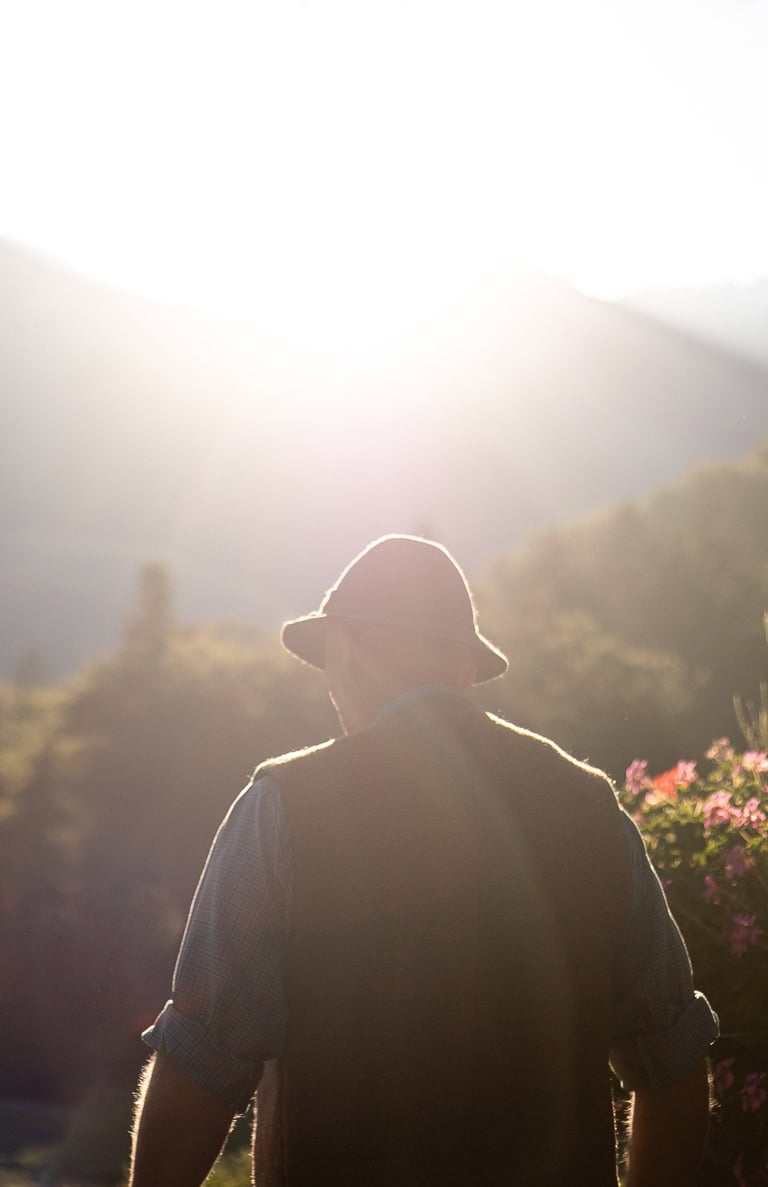 Mann in Tracht genießt den Sonnenuntergang im Chiemgau.